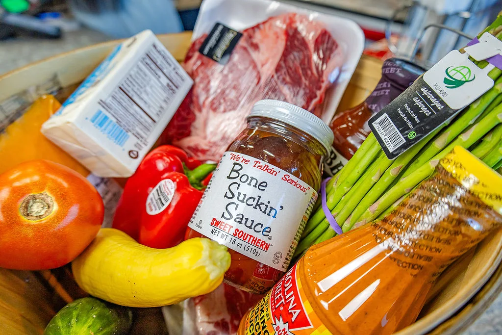 A basket of steak, vegetables, butter, and sauce