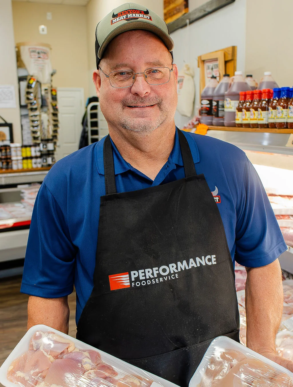 A smiling Kenyon’s crew member with packaged chicken