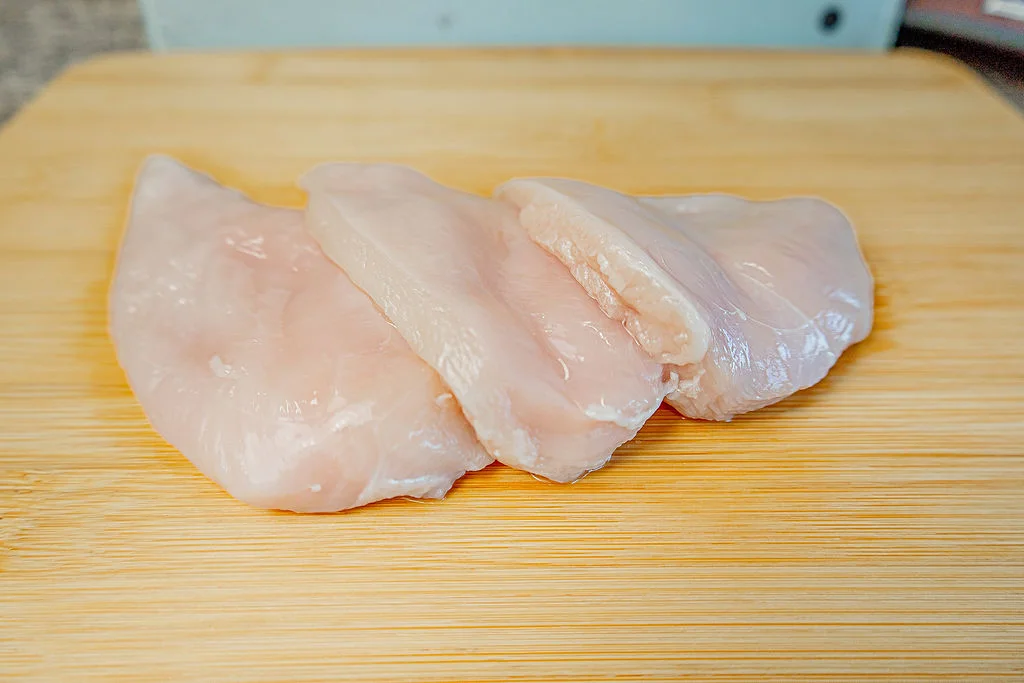 Boneless chicken breasts on a cutting board