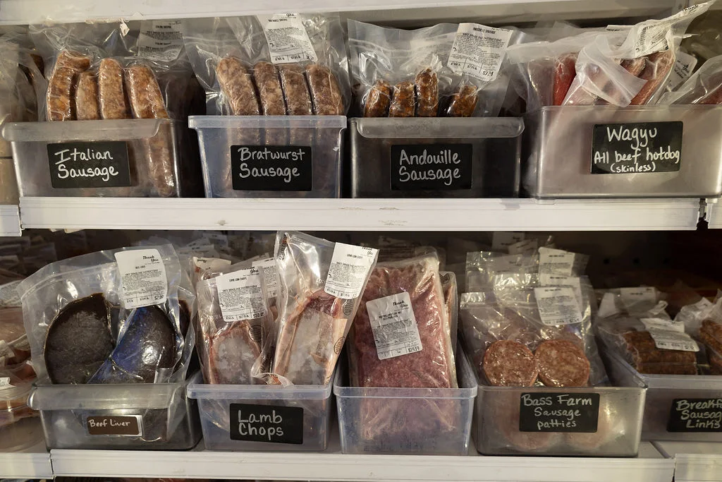 Packaged sausages and lamb chops in the freezer case