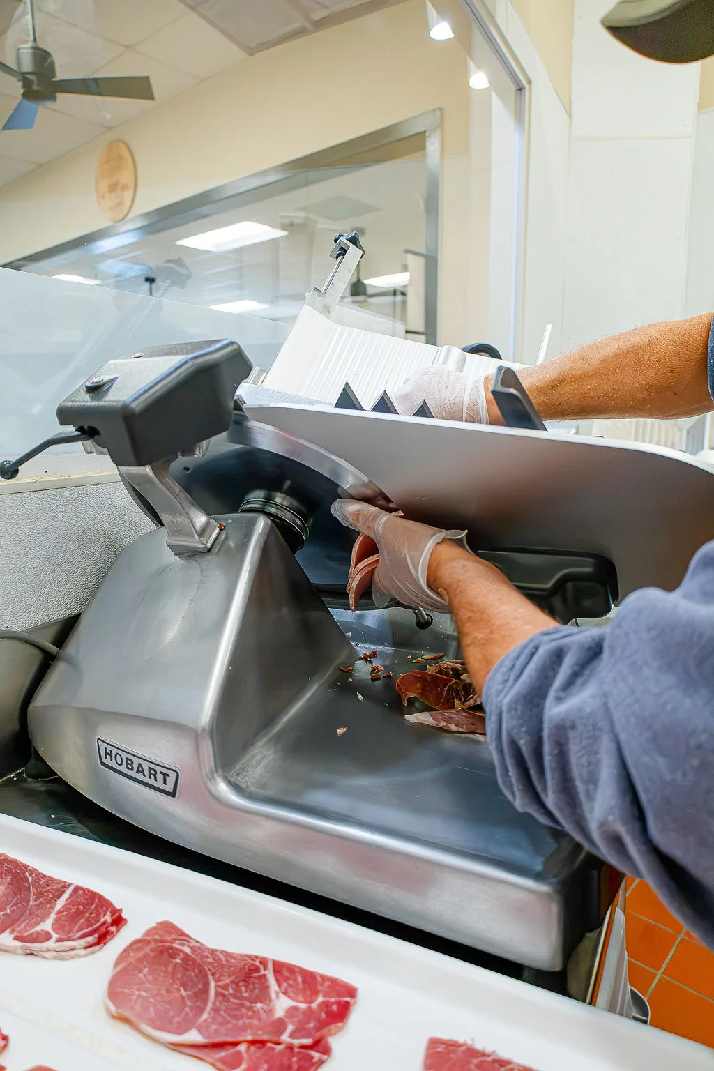 A crew member slicing meat at the market
